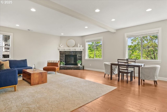 living room with light wood-style flooring, a fireplace, baseboards, and recessed lighting