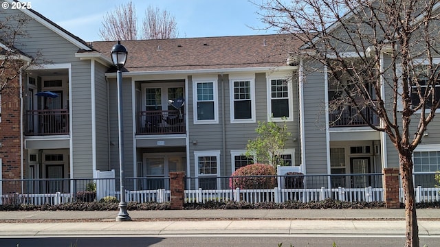 view of front of property featuring fence private yard and roof with shingles
