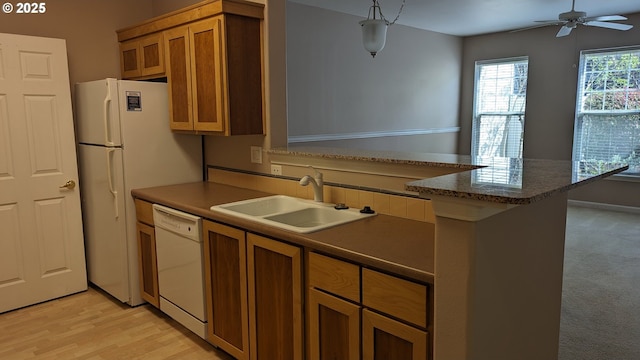 kitchen featuring ceiling fan, a sink, white appliances, brown cabinetry, and a peninsula