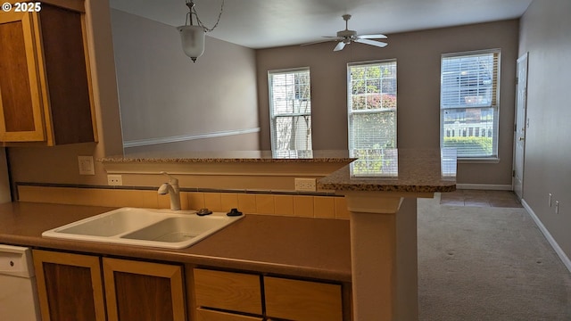 kitchen with ceiling fan, white dishwasher, a sink, a peninsula, and light carpet