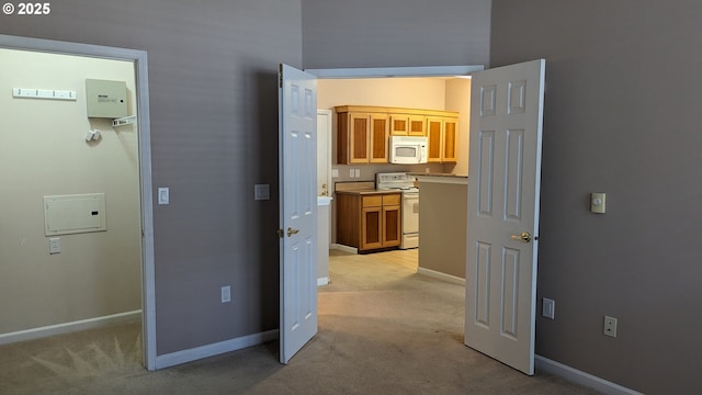 corridor with baseboards and light carpet