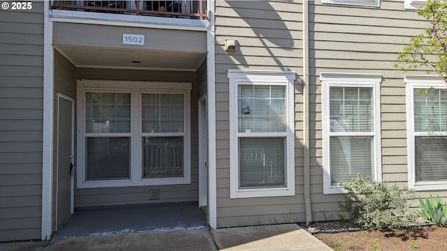 view of exterior entry featuring a balcony