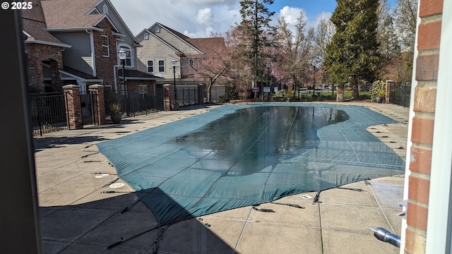 community pool with fence and a patio