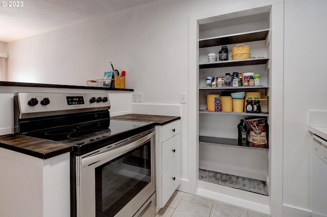 6097 SW Valley Ave, Beaverton, OR 97008 - kitchen featuring electric range, white cabinetry, light tile patterned floors, and butcher block counters