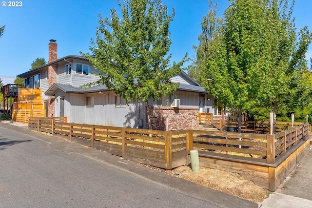 6097 SW Valley Ave, Beaverton, OR 97008 - view of front of property with a chimney, a fenced front yard, and brick siding