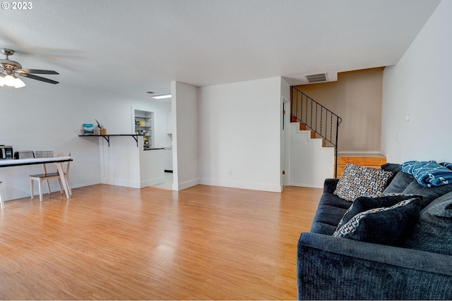 6097 SW Valley Ave, Beaverton, OR 97008 - living room with stairs, light wood-type flooring, a ceiling fan, and baseboards