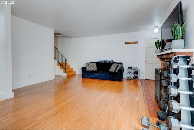 6097 SW Valley Ave, Beaverton, OR 97008 - living room with stairs, wood finished floors, a fireplace, and baseboards
