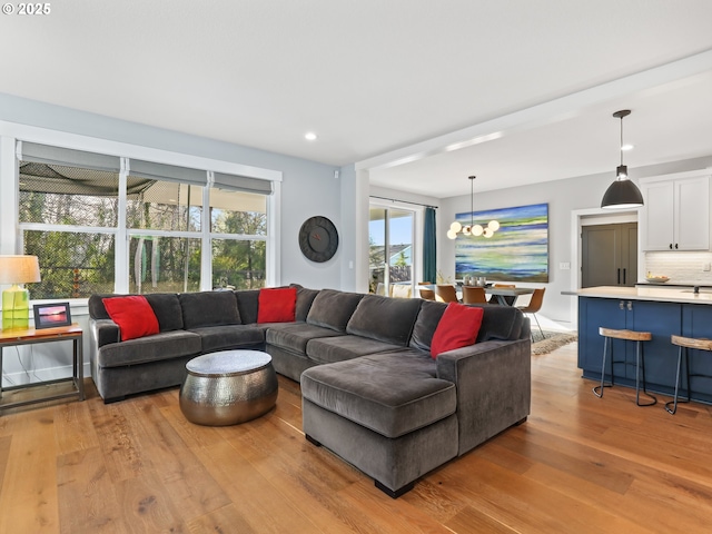 living room featuring an inviting chandelier and light hardwood / wood-style floors