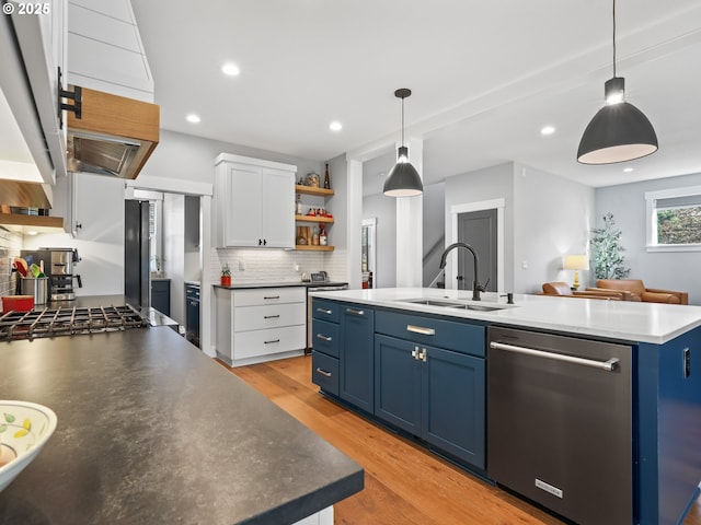 kitchen with a kitchen island, appliances with stainless steel finishes, sink, white cabinets, and blue cabinetry