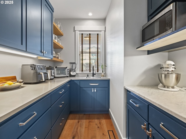 kitchen featuring blue cabinets, sink, and dark hardwood / wood-style floors