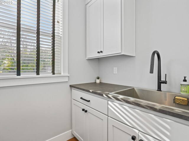 kitchen featuring sink and white cabinets