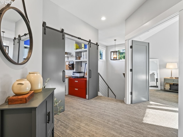 hallway featuring a barn door and carpet