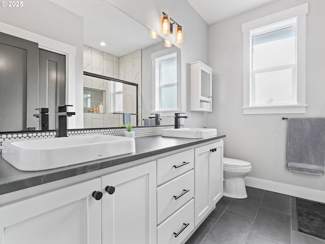 bathroom featuring tile patterned floors, vanity, toilet, and a shower with shower door