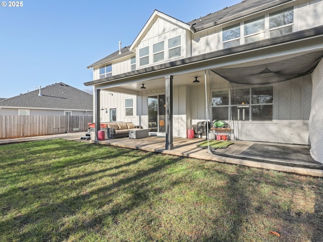 rear view of property with a yard, a patio area, outdoor lounge area, and ceiling fan