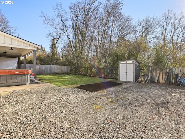 view of yard featuring a storage shed, a hot tub, and a patio