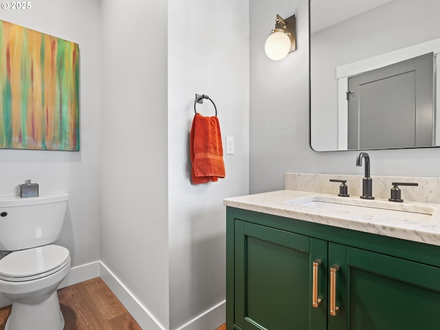 bathroom featuring wood-type flooring, toilet, and vanity