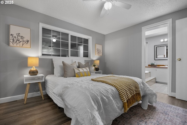 bedroom featuring baseboards, a textured ceiling, ensuite bath, and wood finished floors