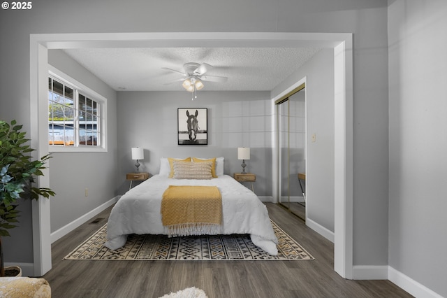 bedroom featuring wood finished floors, baseboards, a closet, and a textured ceiling