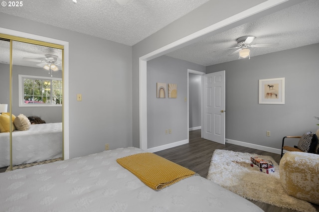 bedroom with a ceiling fan, baseboards, wood finished floors, a closet, and a textured ceiling