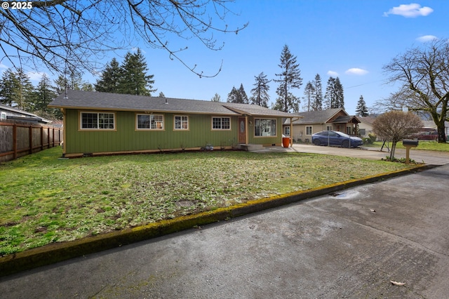 ranch-style home with a front lawn, concrete driveway, and fence