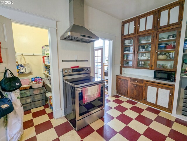 kitchen featuring electric range, wall chimney exhaust hood, light floors, and black microwave
