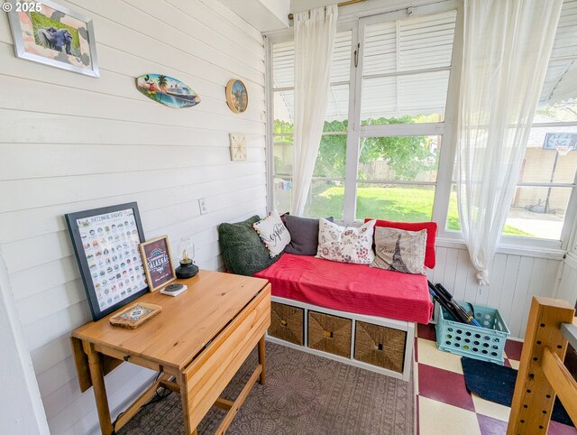 sunroom with wooden walls and tile patterned floors