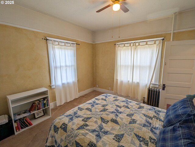 bedroom with radiator, multiple windows, carpet floors, and ceiling fan