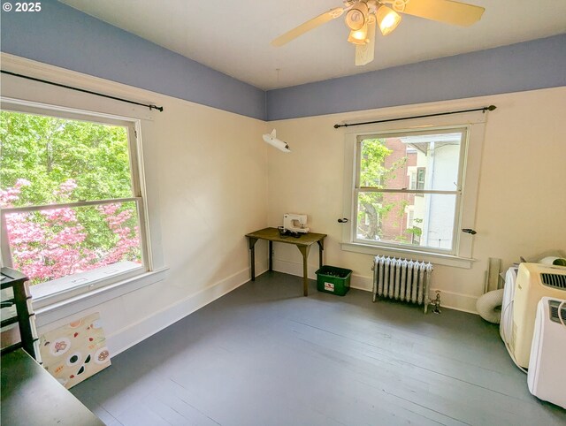 miscellaneous room featuring radiator heating unit, baseboards, and a ceiling fan
