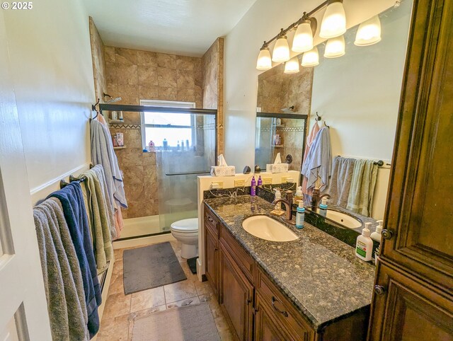 full bath with toilet, vanity, and a stall shower