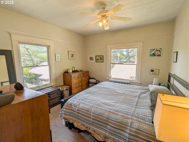 carpeted bedroom with multiple windows and ceiling fan