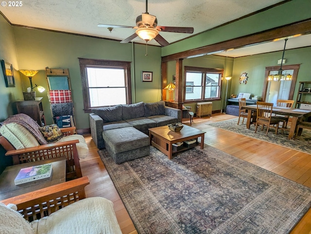 living room with light wood-type flooring, ceiling fan, plenty of natural light, and a textured ceiling