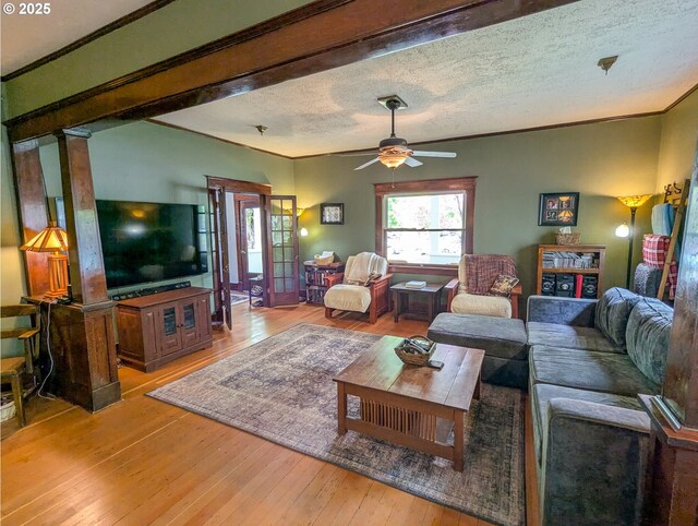 living room with hardwood / wood-style floors, ornamental molding, ceiling fan, and a textured ceiling