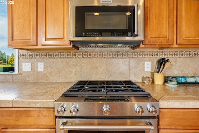 1761 S 18th Cir, Ridgefield, WA 98642 - kitchen with stainless steel appliances, decorative backsplash, and tile countertops