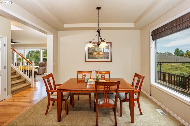 1761 S 18th Cir, Ridgefield, WA 98642 - dining area featuring a tray ceiling, stairs, a chandelier, and light wood finished floors