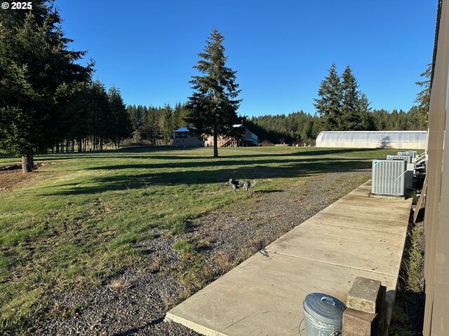 view of yard featuring cooling unit and an outdoor structure