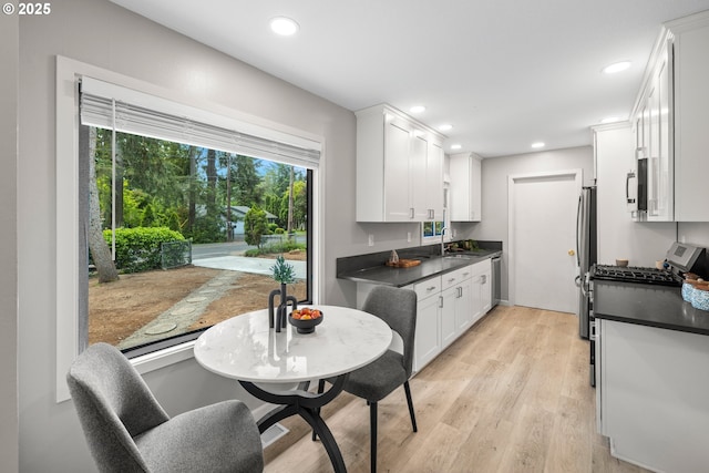 6401 Mcewan Rd, Lake Oswego, OR 97035 - kitchen featuring a sink, dark countertops, white cabinetry, light wood-style floors, and recessed lighting