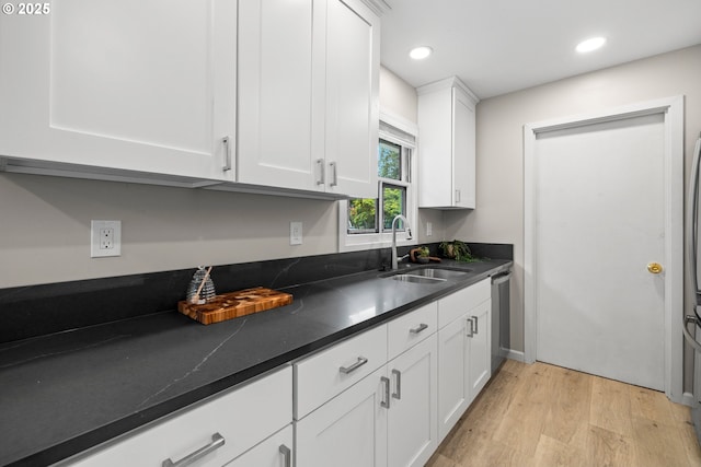 6401 Mcewan Rd, Lake Oswego, OR 97035 - kitchen featuring a sink, light wood finished floors, dark countertops, white cabinets, and dishwasher