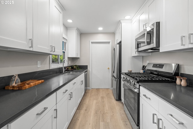 6401 Mcewan Rd, Lake Oswego, OR 97035 - kitchen featuring stainless steel appliances, a sink, light wood finished floors, recessed lighting, and white cabinetry