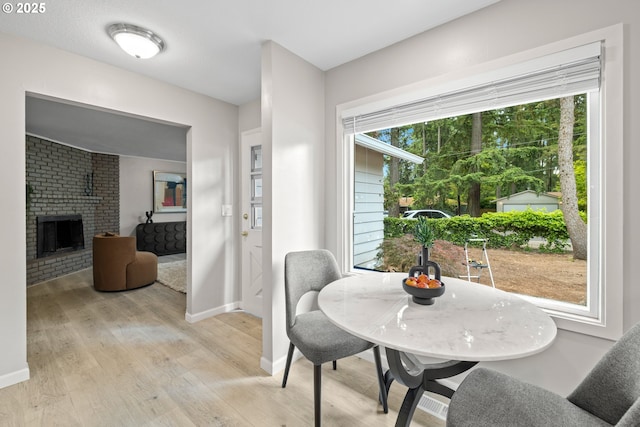 6401 Mcewan Rd, Lake Oswego, OR 97035 - dining space with light wood-style floors, baseboards, and a brick fireplace