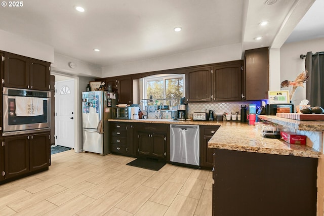 4247 Redwood Hwy, Grants Pass, OR 97527 - kitchen with appliances with stainless steel finishes, dark brown cabinets, backsplash, recessed lighting, and a peninsula