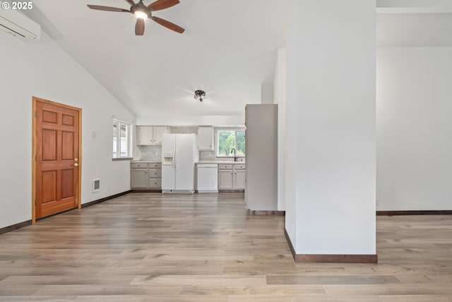 86336 N Modesto Dr, Eugene, OR 97402 - unfurnished living room featuring an AC wall unit, ceiling fan, lofted ceiling, light wood-style floors, and healthy amount of natural light