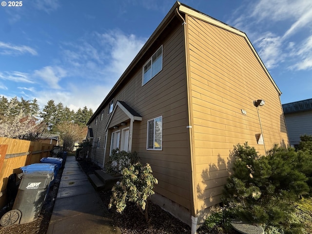view of side of home featuring fence