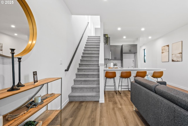 stairs featuring wood-type flooring and sink