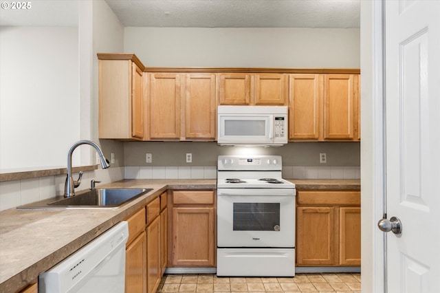 kitchen featuring sink, a textured ceiling, and white appliances