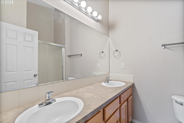 bathroom with vanity, toilet, and a shower with door