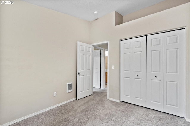 unfurnished bedroom featuring light colored carpet and a closet