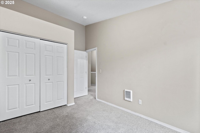 unfurnished bedroom featuring a closet and light carpet