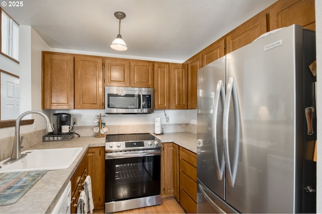2251 SW Trachsel Dr, Beaverton, OR 97003 - kitchen with stainless steel appliances, a sink, brown cabinetry, and light countertops