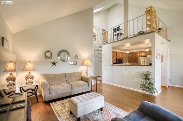 2251 SW Trachsel Dr, Beaverton, OR 97003 - living area with high vaulted ceiling, baseboards, wood finished floors, and stairs