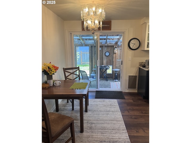 dining space featuring a chandelier and dark wood-style floors